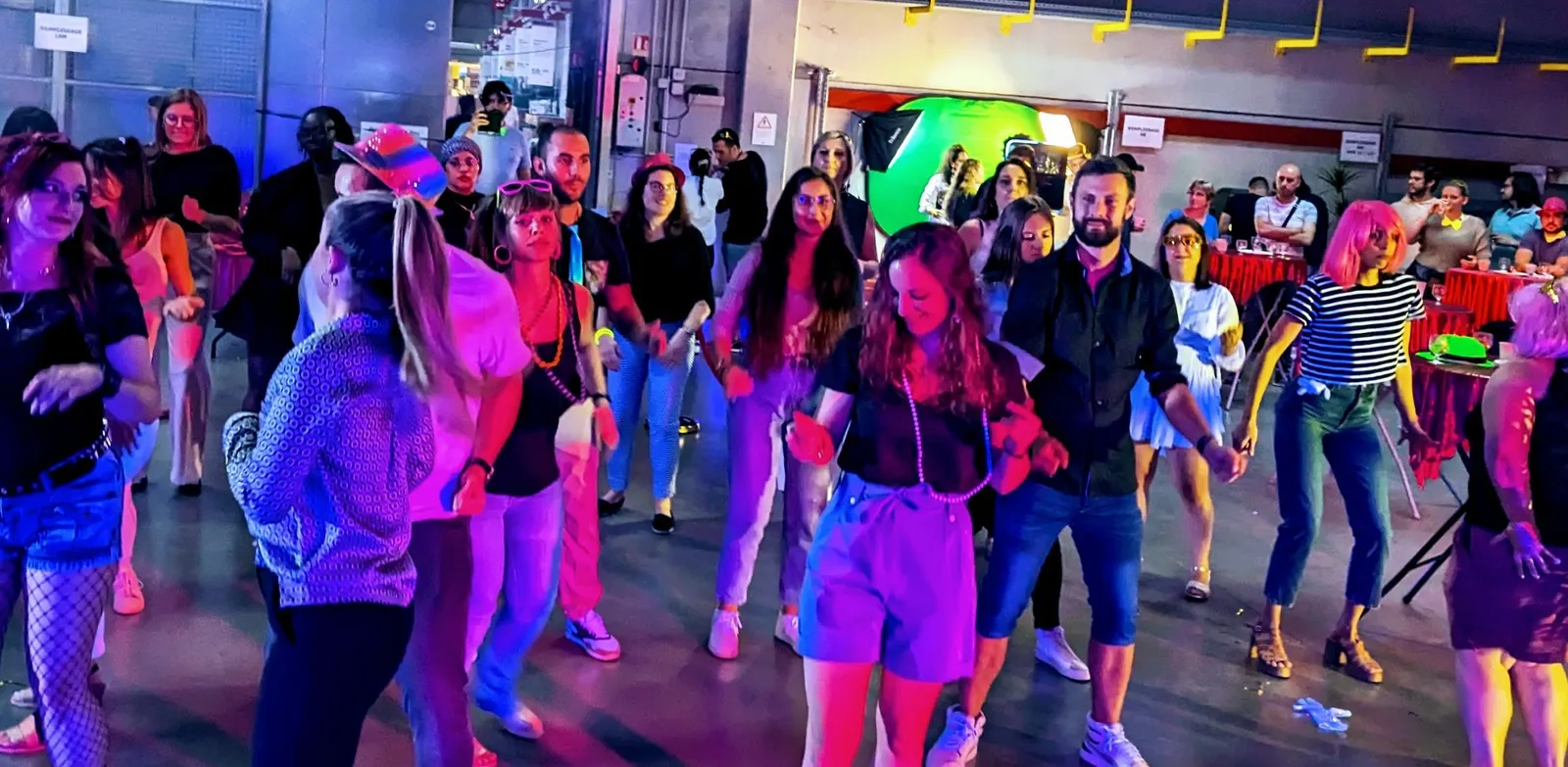 Invités qui dansent sous les lumières colorées dans un grand hall