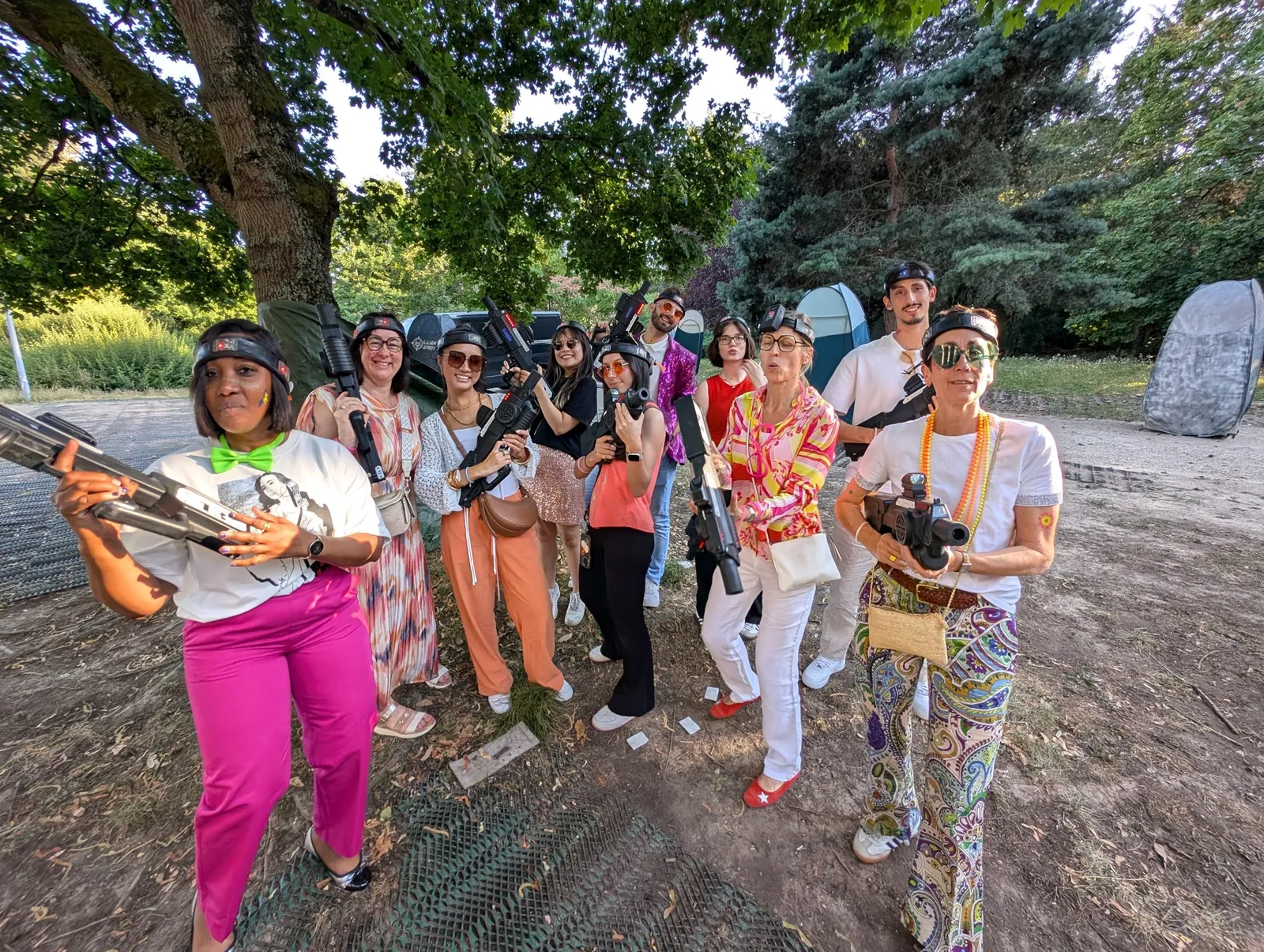 Groupe de joueurs en tenues colorées posant avec leurs pistolets laser dans un parc