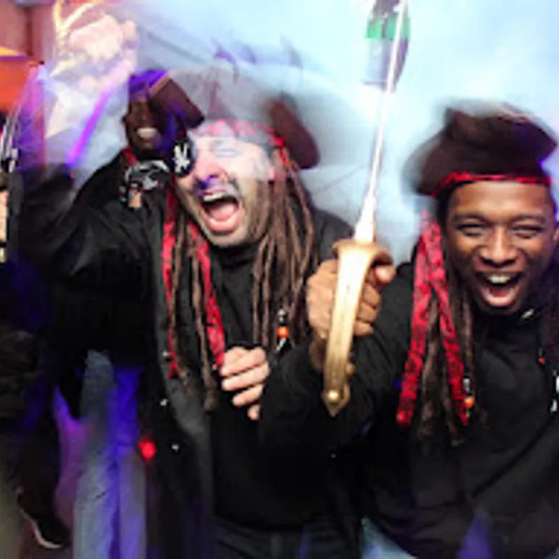 Deux pirates hilares, sabre à la main, sous les lumières de la soirée